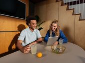 Man en vrouw kijken samen naar tablet en drinken thee