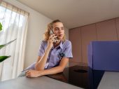 Vrouw in paars jasje heeft telefoon aan oor