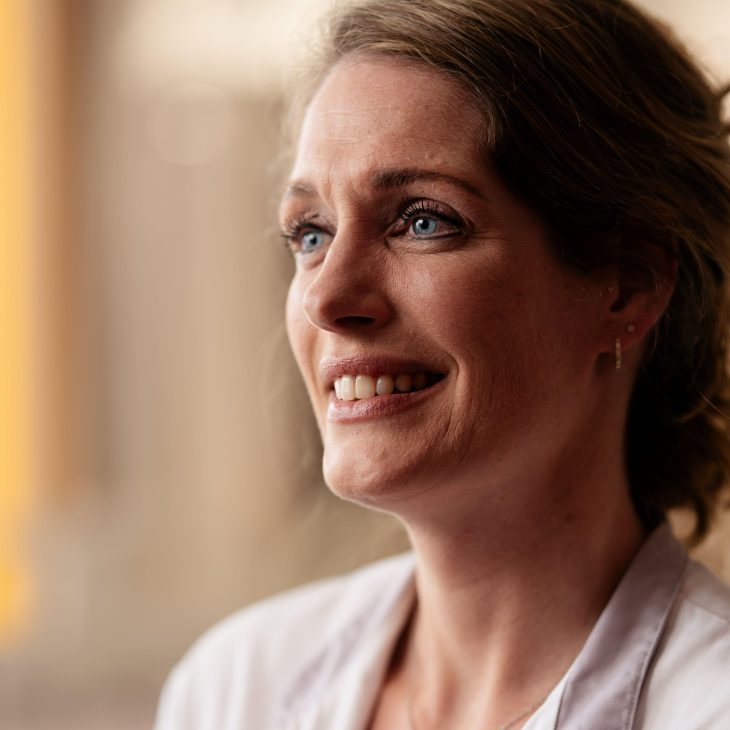Portret van blonde vrouw in witte verpleegkundige jas