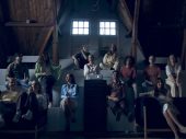 Een filmzaal of bioscoop met tribune waarop verschillende mensen zitten, zowel mannen als vrouwen wachtend tot de film begint.