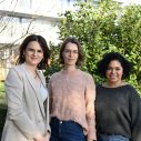 Drie vrouwen staan naast elkaar in natuurlijke omgeving buiten