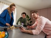 3 zorgmedewerkers kijken naar tablet
