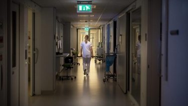 Zorgmedewerker loopt door ziekenhuisgang