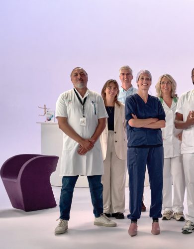 Groep van 9 zorgmedewerkers in witte en blauwe kleding