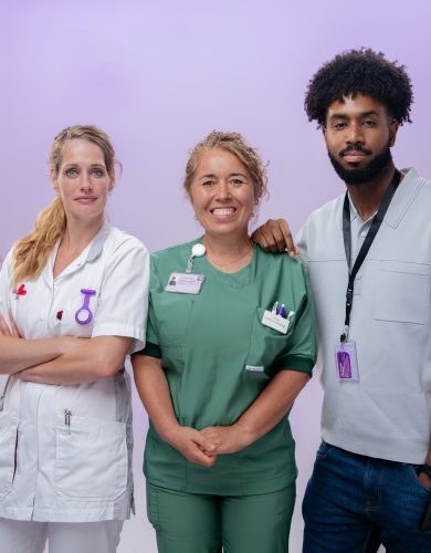 2 blonde vrouwen en een man met zwart haar. eerste vrouw draagt een witte verpleegkundige jas, tweede vrouw een operatiekamer outfit.