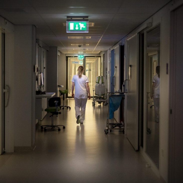 Zorgmedewerker loopt door ziekenhuisgang