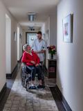 Beeld verpleger met vrouw in rolstoel op website IZZ 2023 