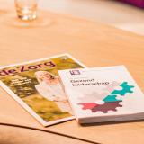 Het Magazine de Zorg ligt op een tafel. 